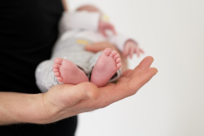 foto-de-foco-seletivo-de-uma-pessoa-carregando-um-bebe-recem-nascido