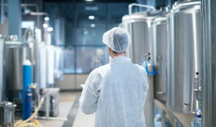 rdf14_portal-tecnologo-em-traje-de-protecao-branco-caminhando-pela-linha-de-producao-da-fabrica-de-alimentos-verificando-a-qualidade_700 (1)